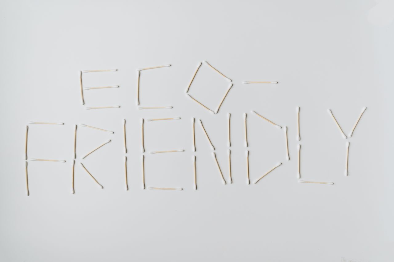 Cotton swabs spelling out eco-friendly on a clean white surface.